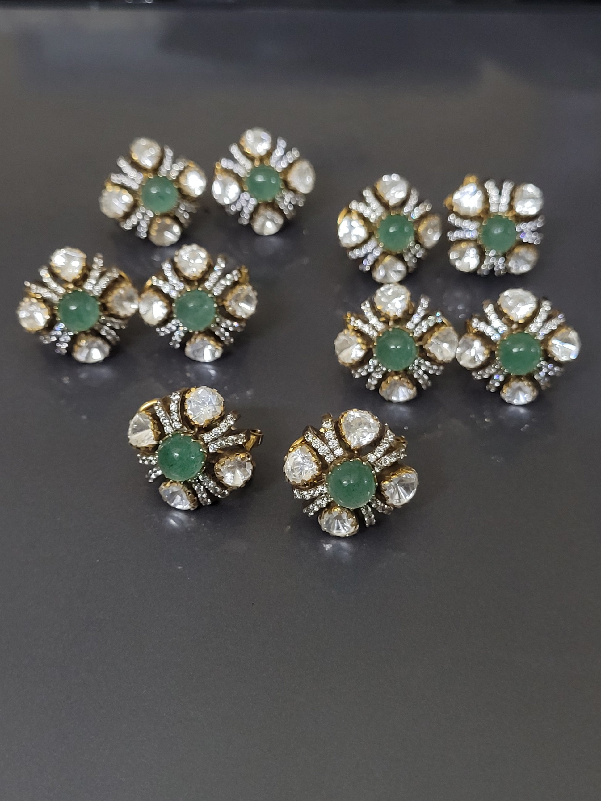 Gold and diamond earrings with red gemstones on a gray background