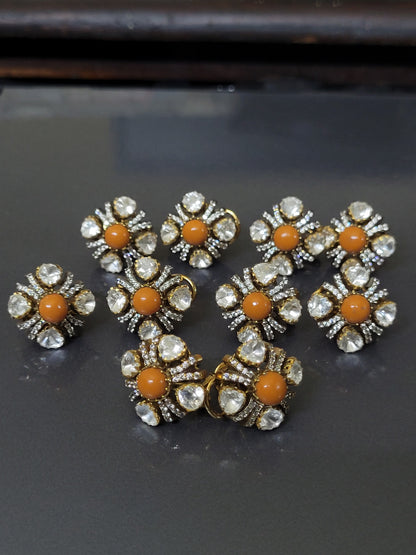 Gold and diamond earrings with red gemstones on a gray background