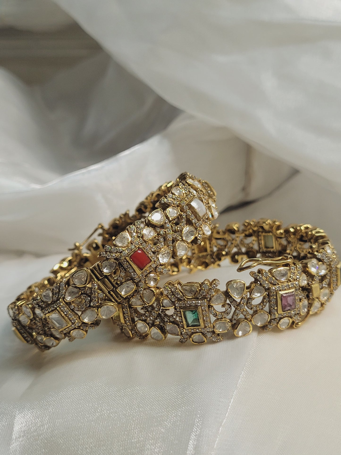 Gold gemstone bangles jewellery, traditional bridal bracelet set with intricate design on white fabric background