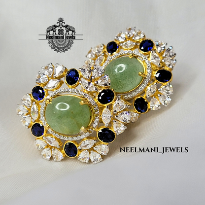 Pair of earrings with green gemstones and blue stones, branded 'Neelemani Jewels'.